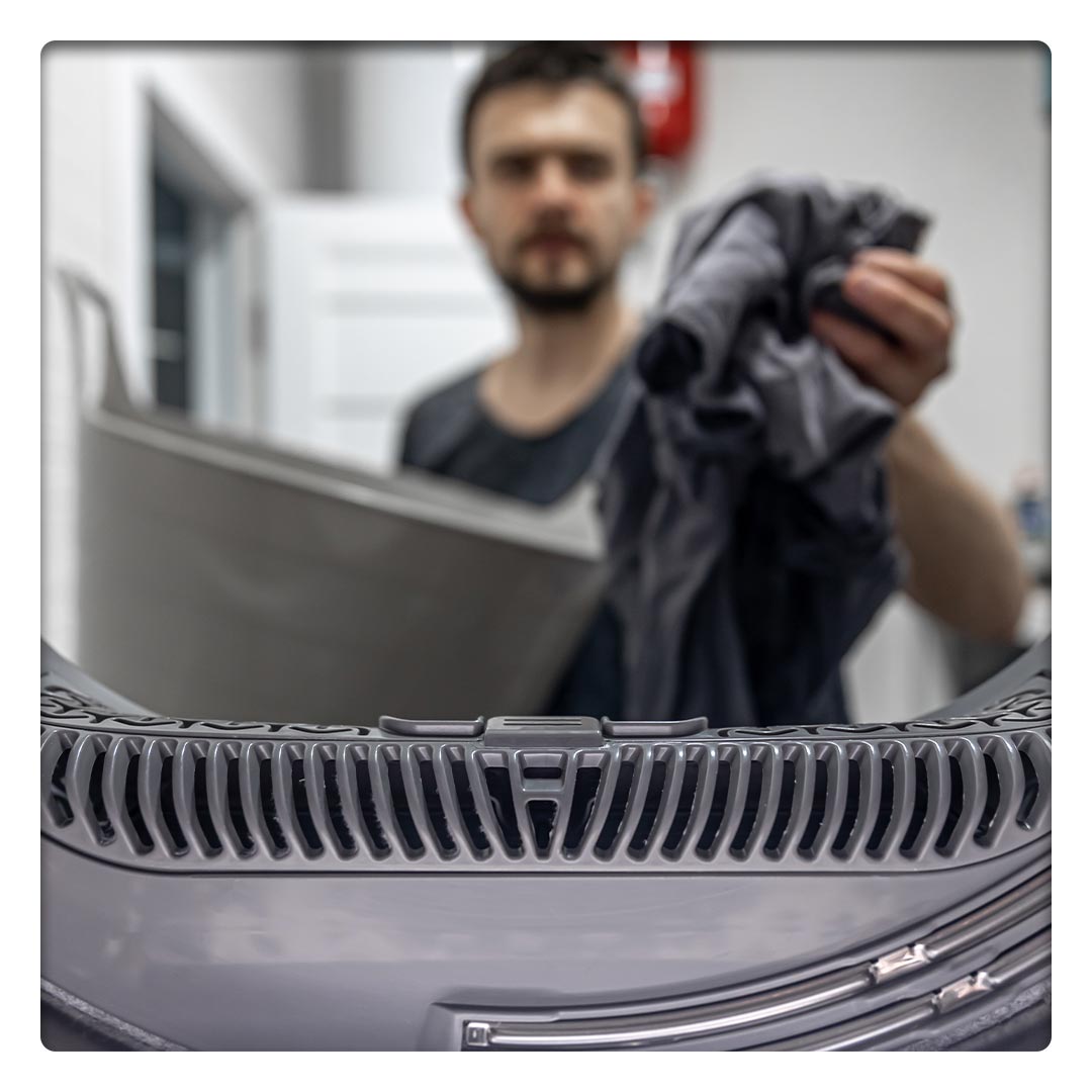 Man Removing Laundry from dryer.